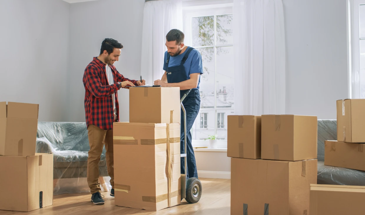 People organizing moving boxes in living room